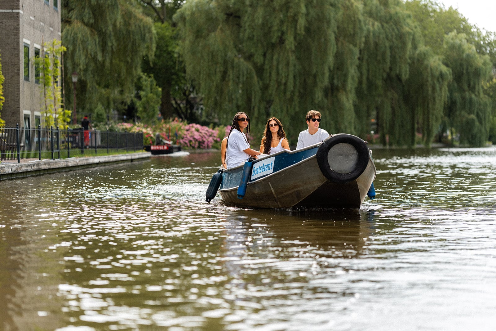 Friends enjoying a boat ride on the Amsterdam canals – ideal as a gift voucher